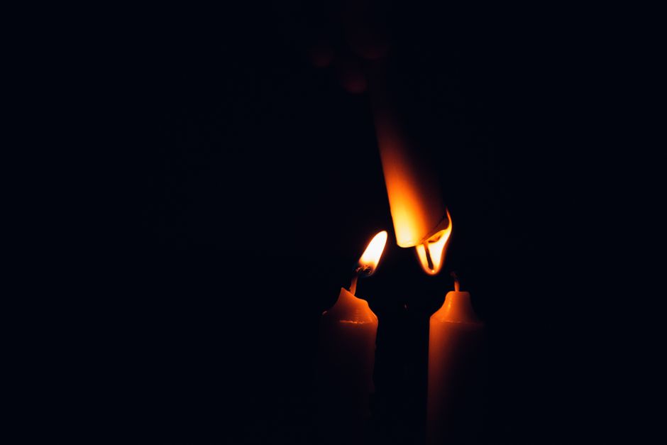 Close-up of candle flames against a dark background, offering warm illumination.